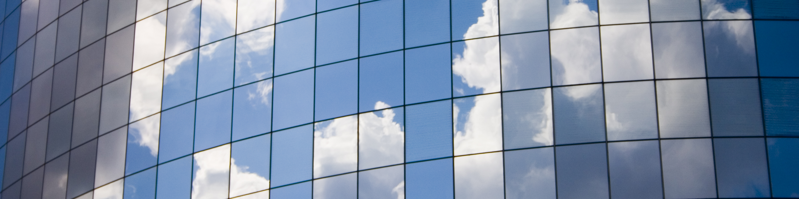 Futuristic abstract business background with reflected blue skies and clouds,