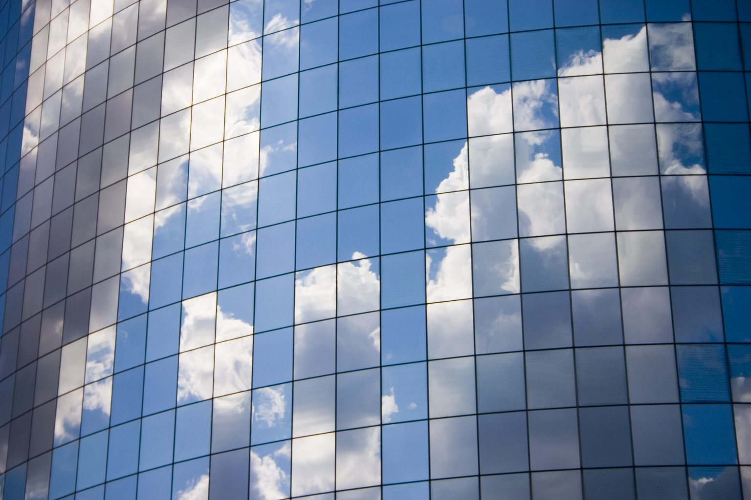 Futuristic abstract business background with reflected blue skies and clouds,