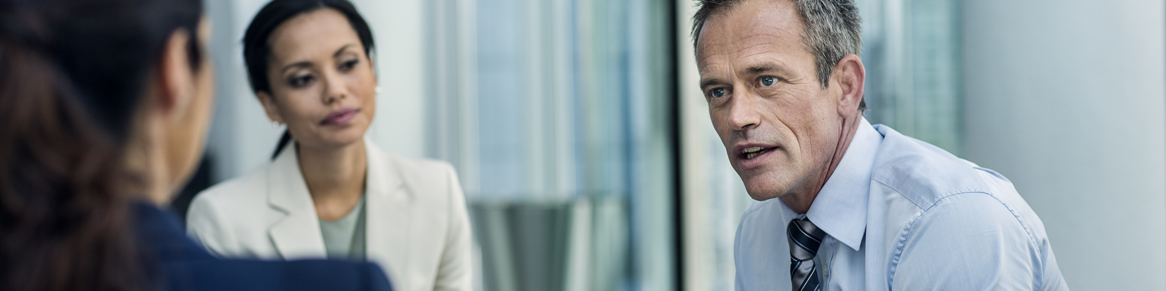 Businessman discussing strategy with female colleagues in office