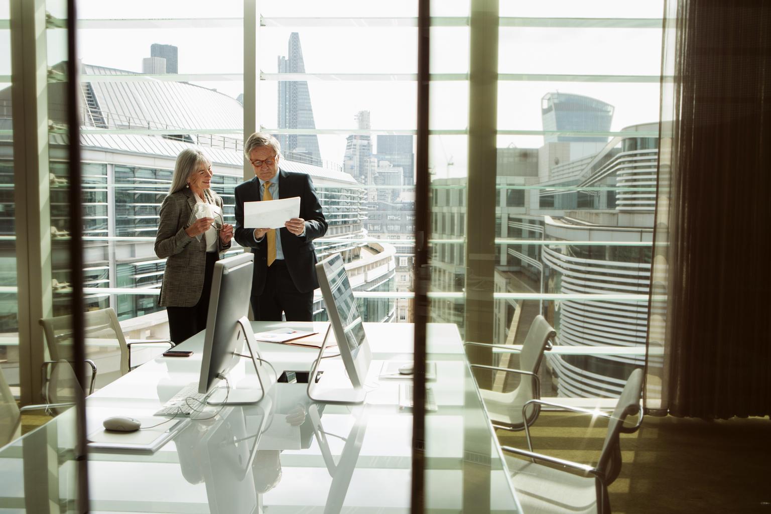 Businessman and businesswoman reading and analyzing report