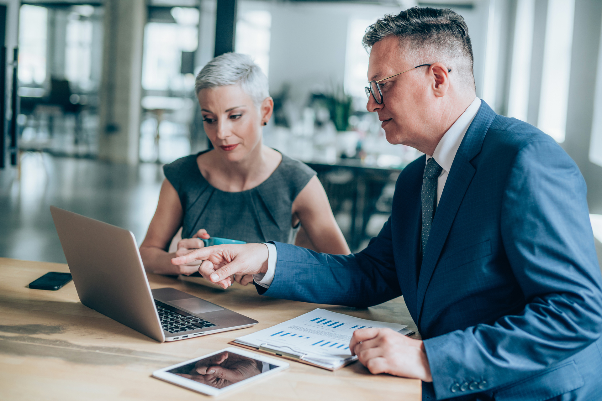 Shot of a two serious business persons talking together in a modern office