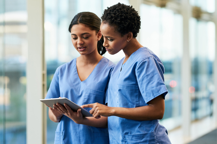 Two nurses consult information on tablet