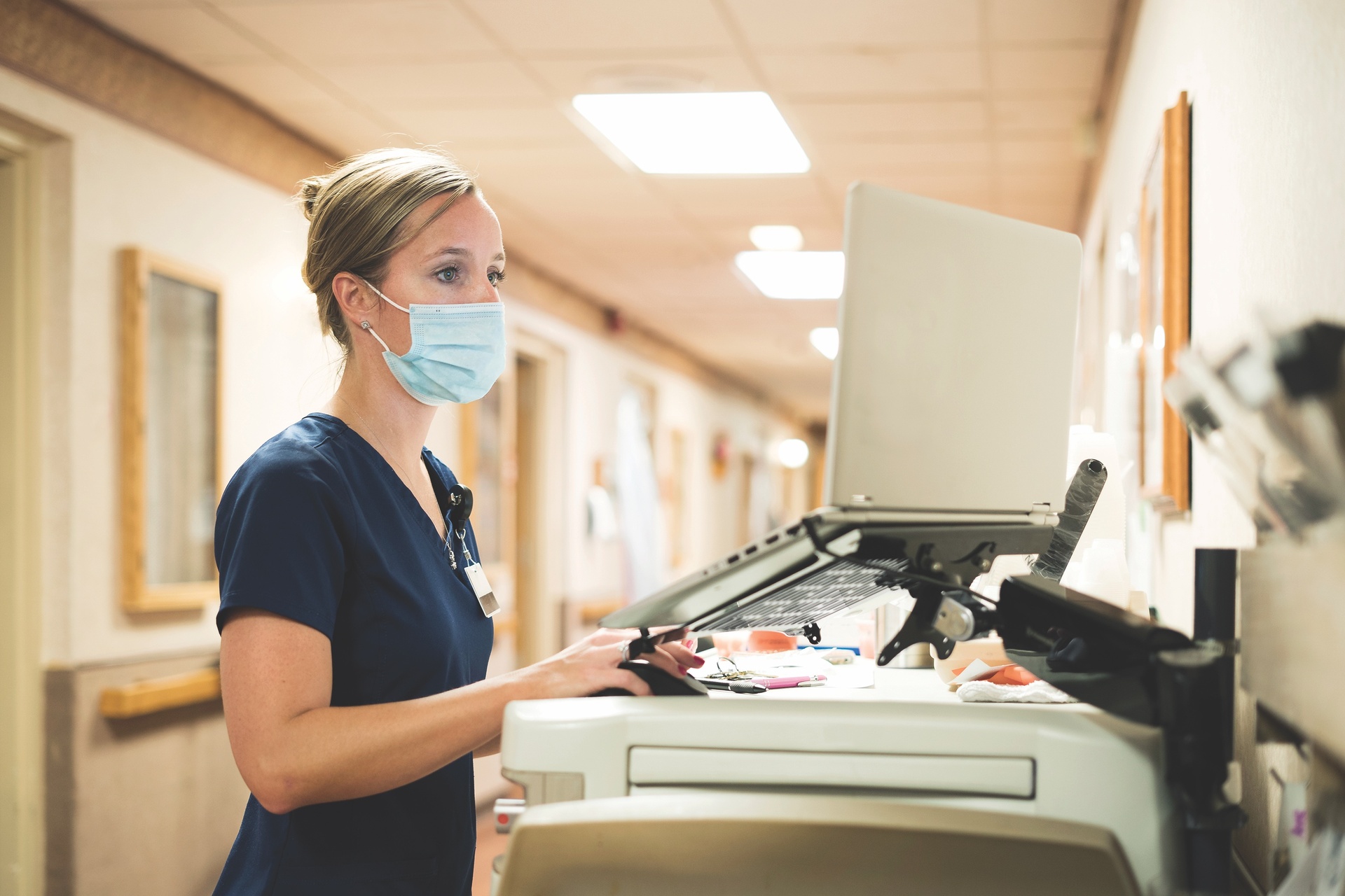 Nurse using laptop wearing face mask