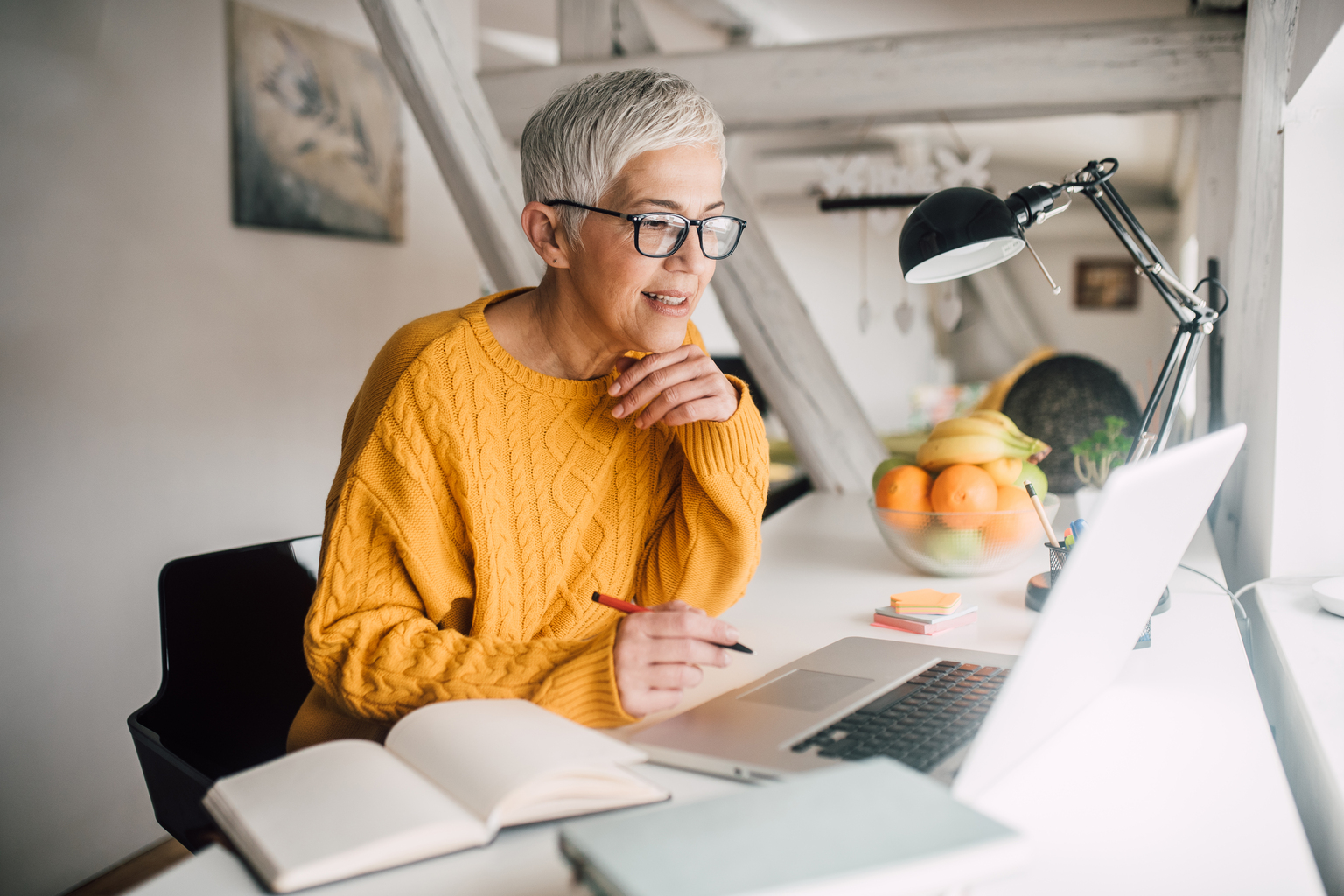 A senior adult using laptop in her modern house