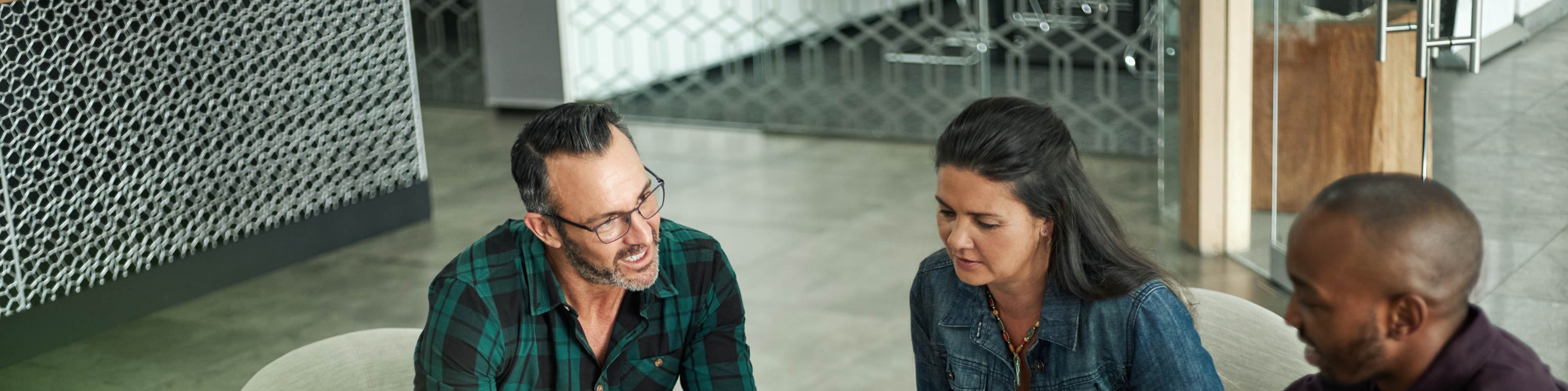 Two men and a woman having a discussion in an office