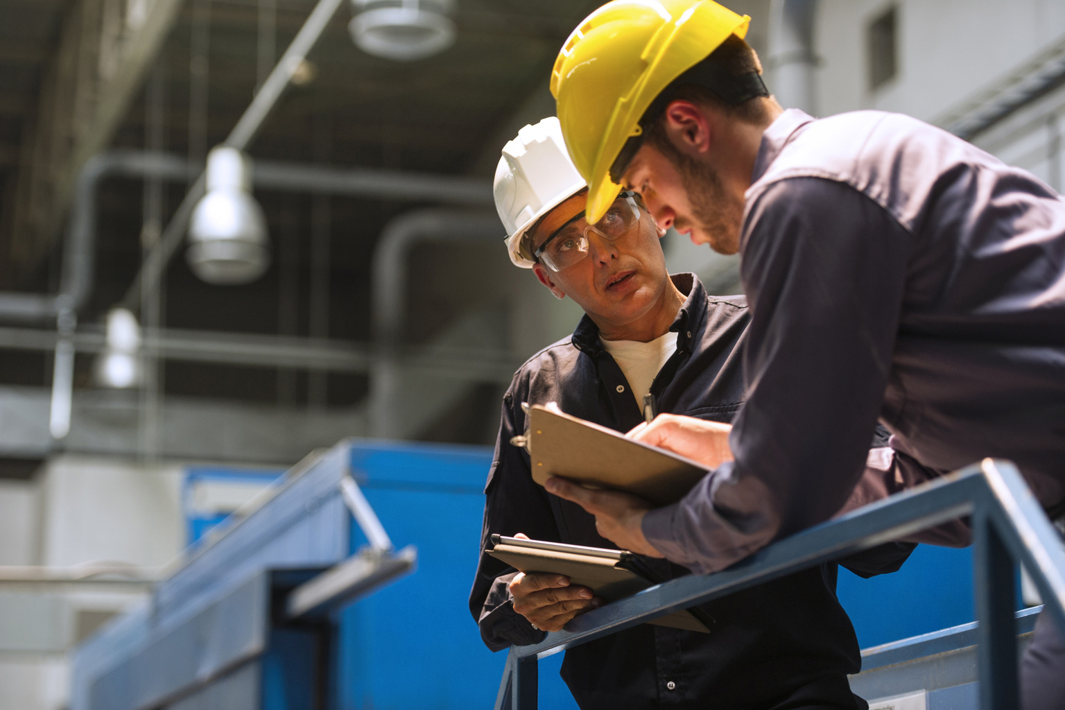 Factory workers discussing with each other in factory