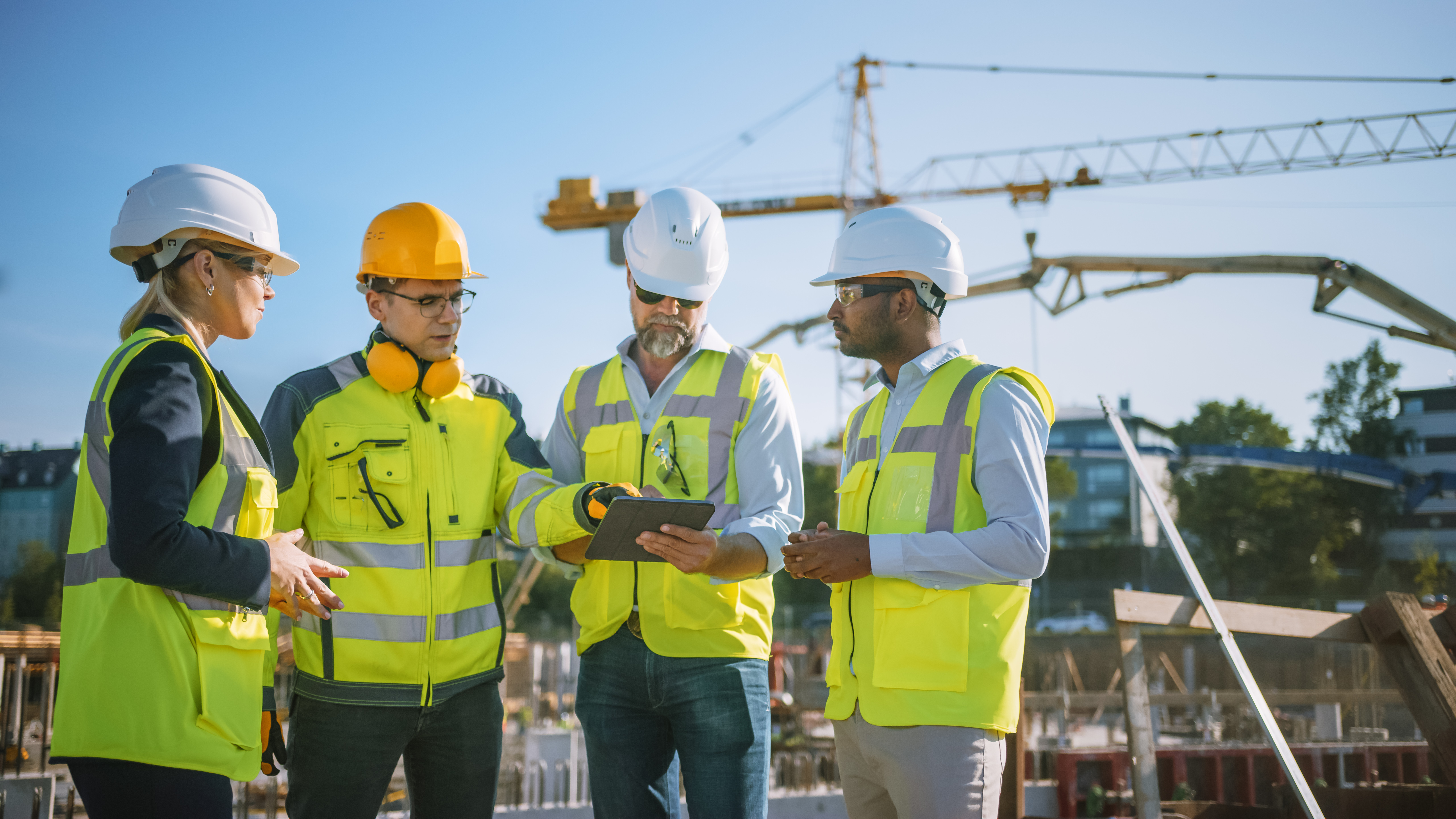 Diverse Team of Specialists Use Tablet Computer on Construction Site. Real Estate Building Project with Civil Engineer, Architect, Business Investor and General Worker Discussing Plan Details.