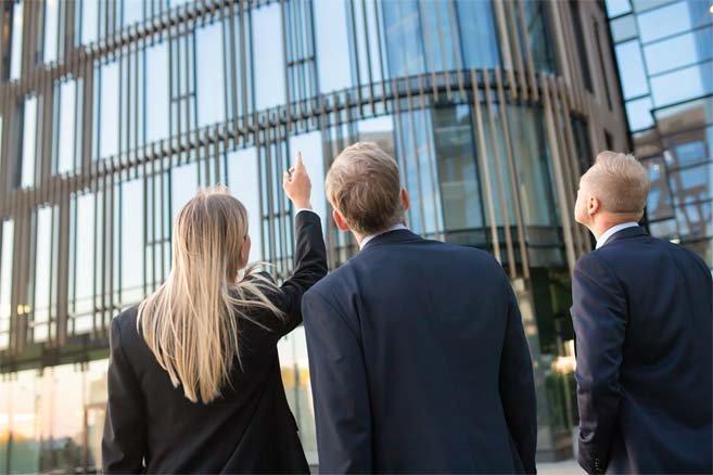 people looking up at a commercial office building