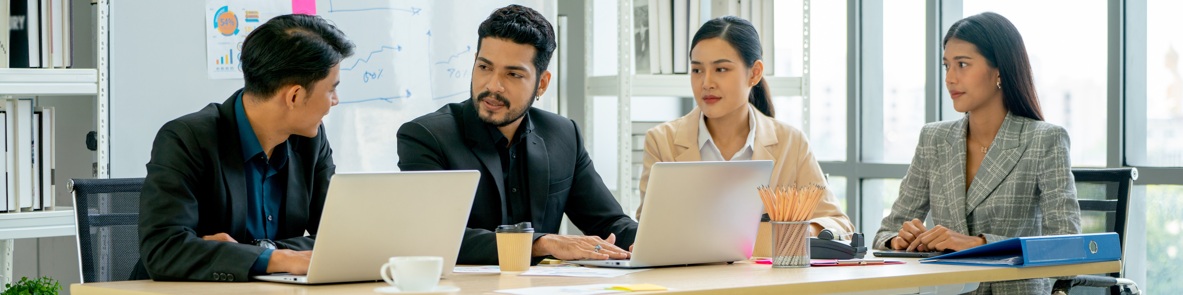 Men and women sitting around a table in office having discussion