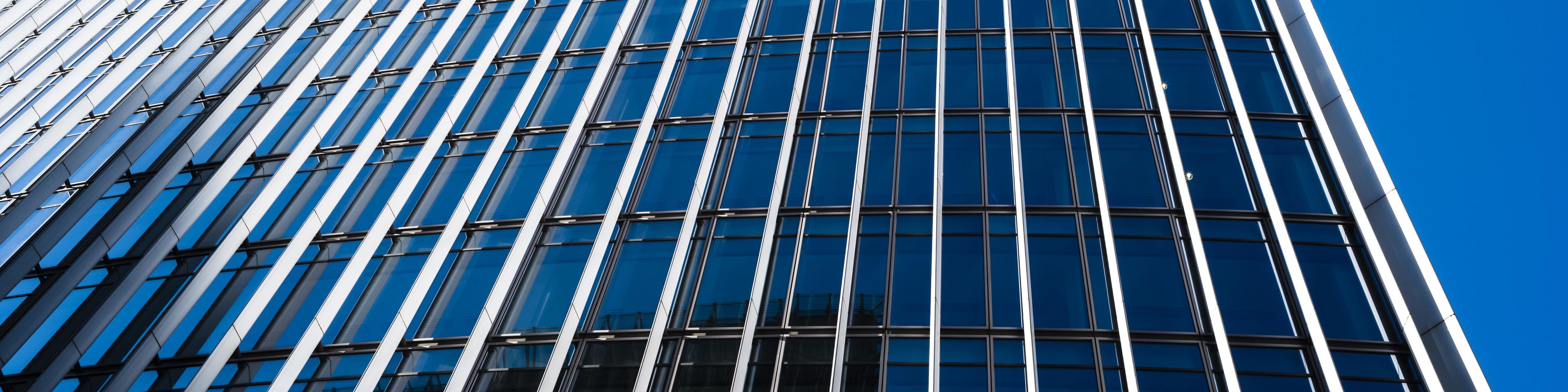 UK, London, looking up at a city skyscraper in the financial district against clear sky