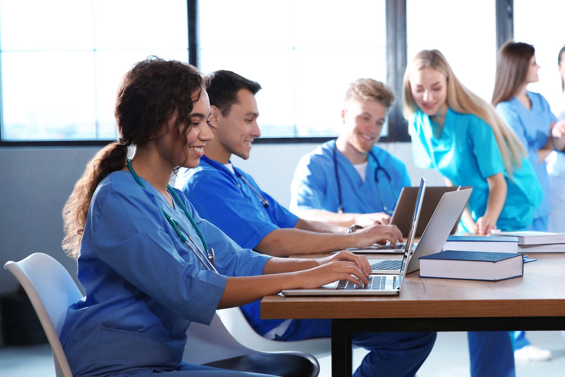 Group of nurses working at laptops in conference room