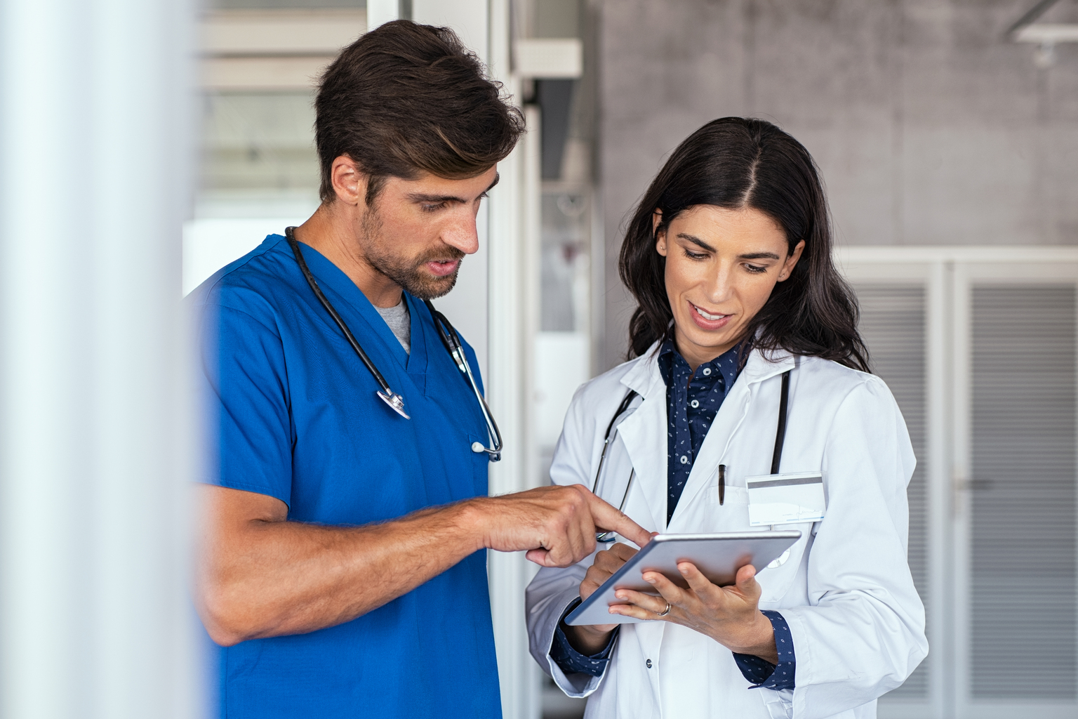 Doctor and nurse discussing over a medical report in hospital