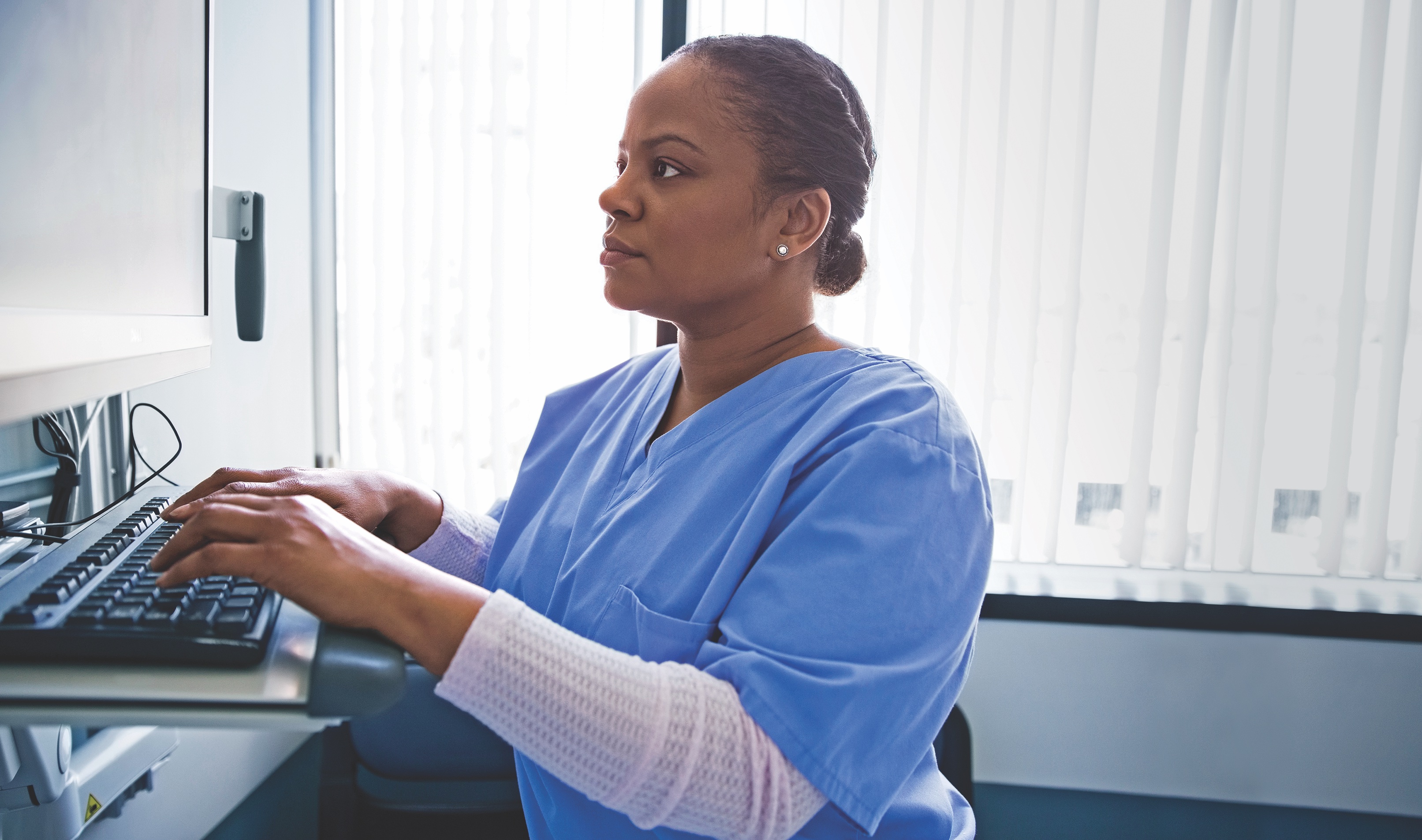 Nursing typing on laptop station