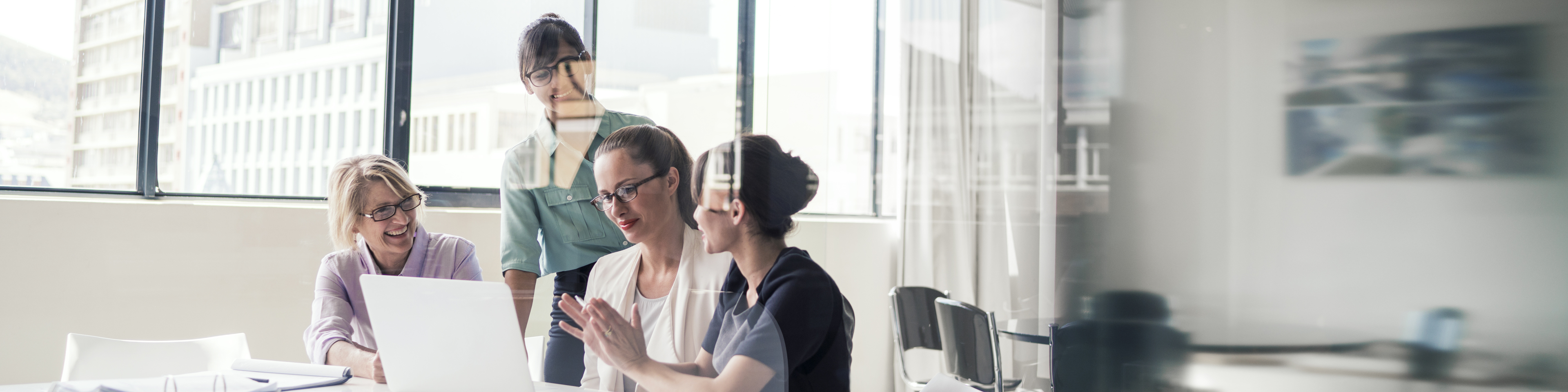 Multi-ethnic businesswomen discussing over laptop in office