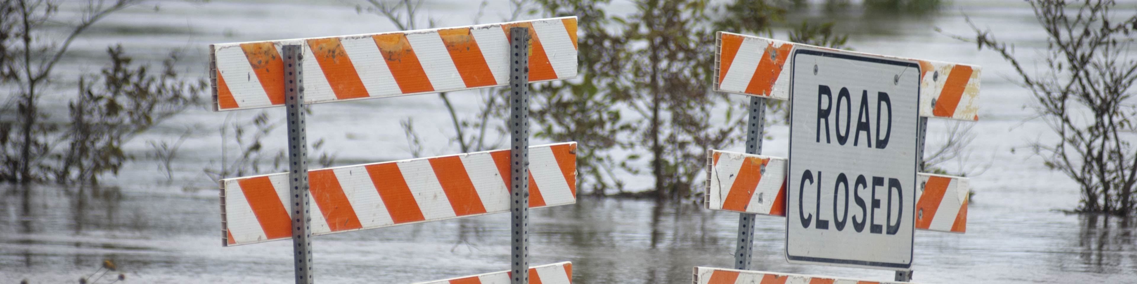 Flooded road with a sign that says Road Closed