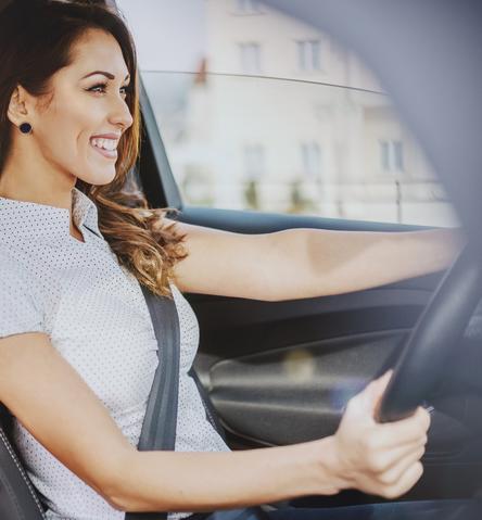 Woman in front seat of Nissan car