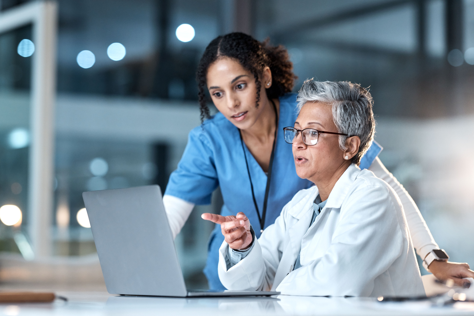 Two medical professionals meeting to review information on a laptop