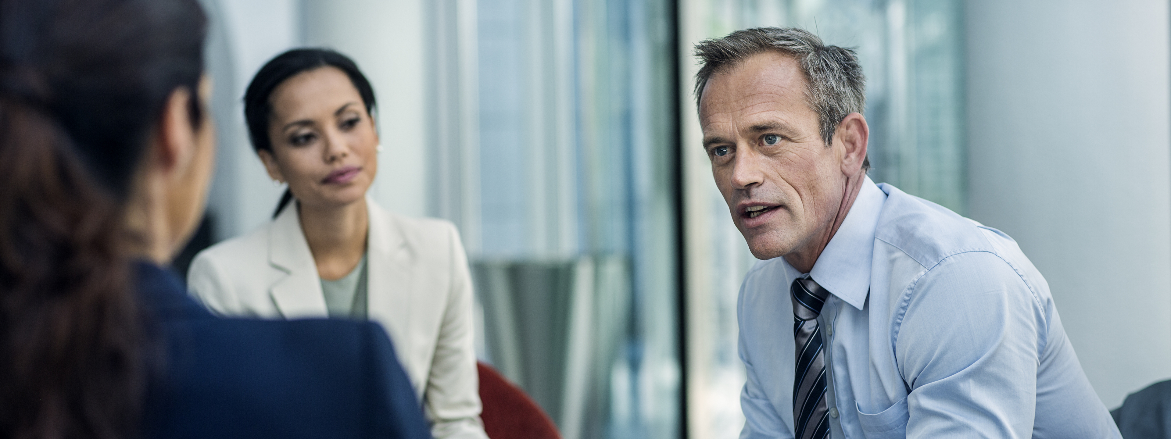 Businessman discussing strategy with female colleagues in office