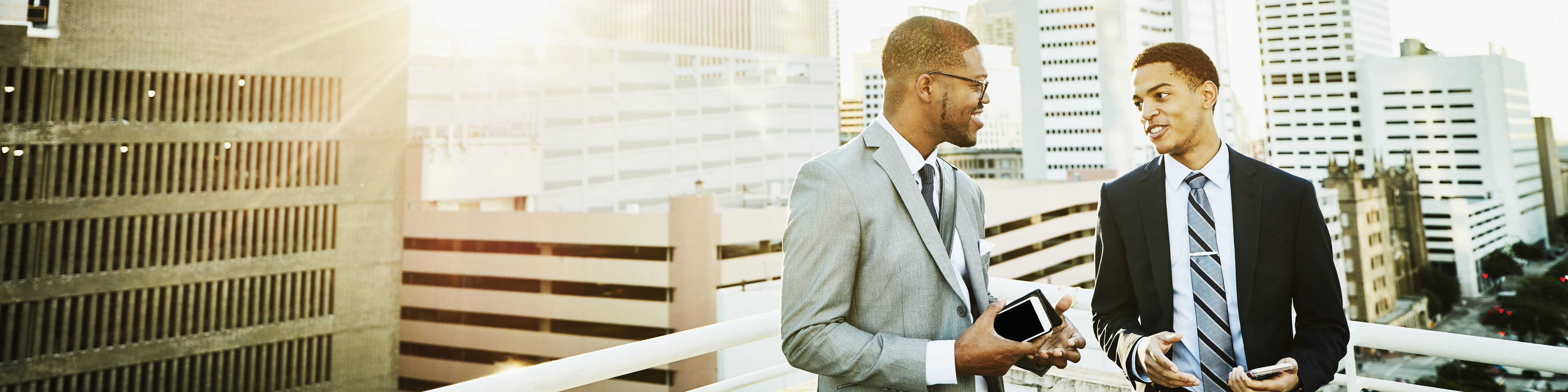 Two businessmen in discussion on downtown office deck