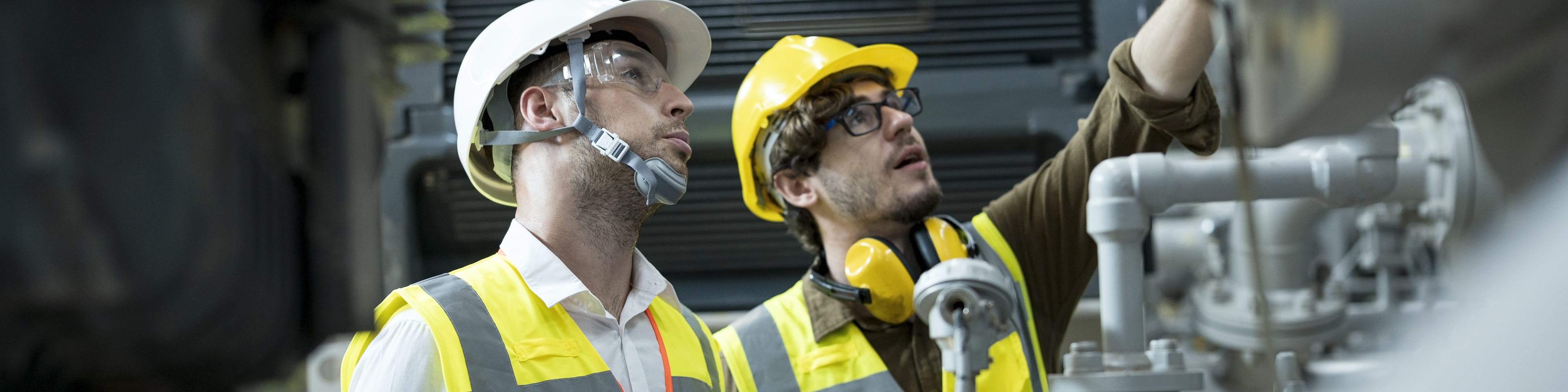 Service engineer explaining to businessman about the HVAC system (Heating, Ventilation and Air Conditioning) in control room shop floor of factory