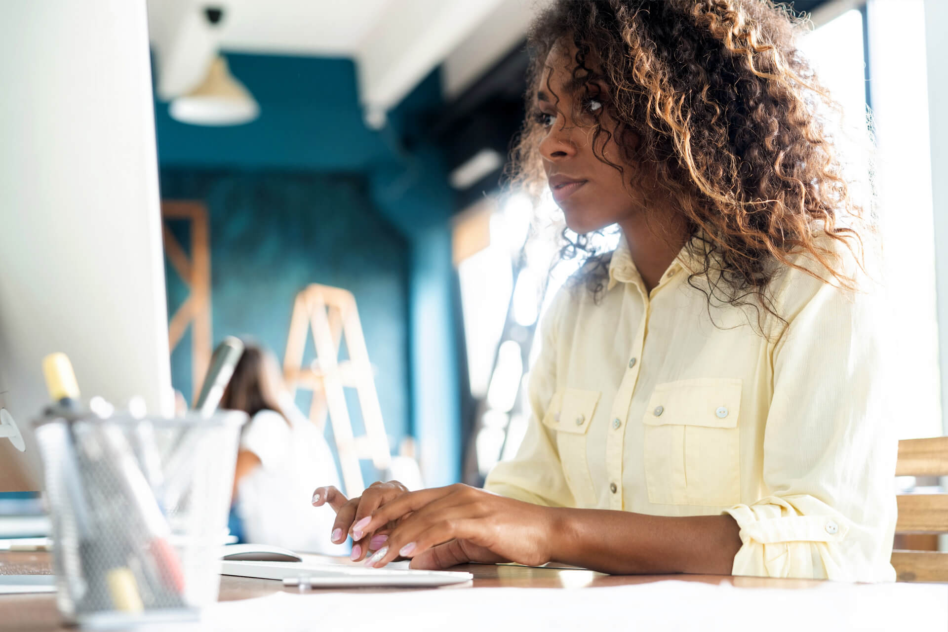 A woman typing on a computer keyboard while learning about CCH Axcess Open Integration APIs