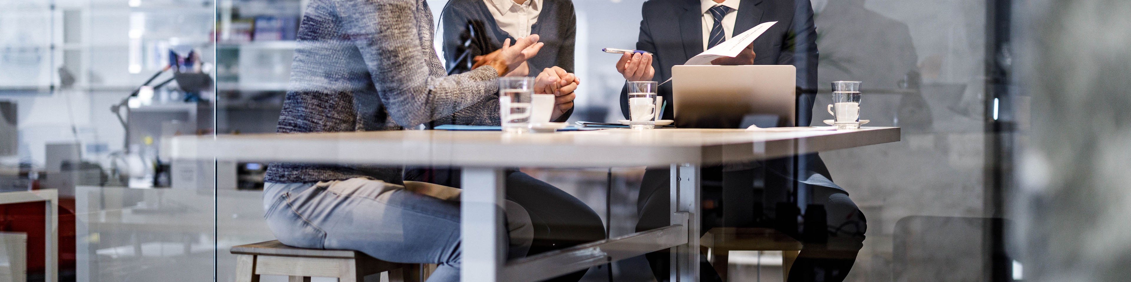 Young happy couple talking to their insurance agent during a meeting in the office