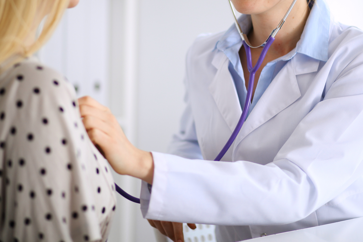 Doctor examining patient using stethoscope