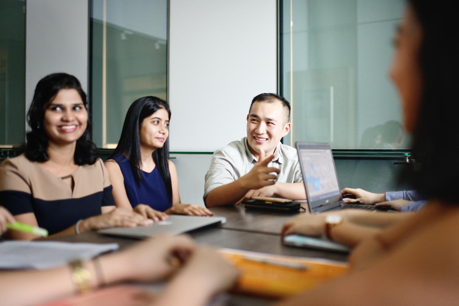 Man speaking during a meeting, women colleagues distracted