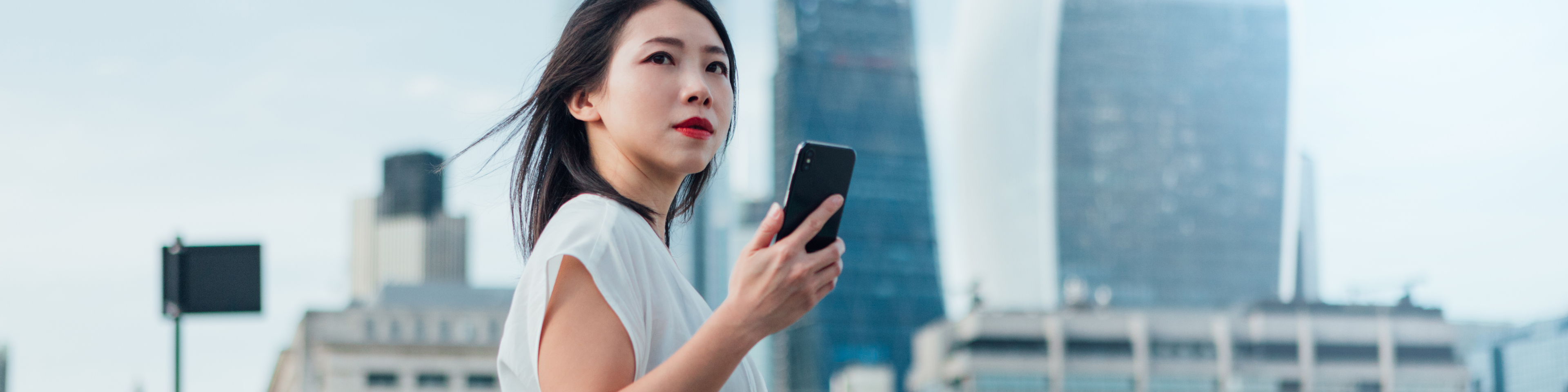 Confident Businesswoman Commuting To Work With Smart Phone In The City 