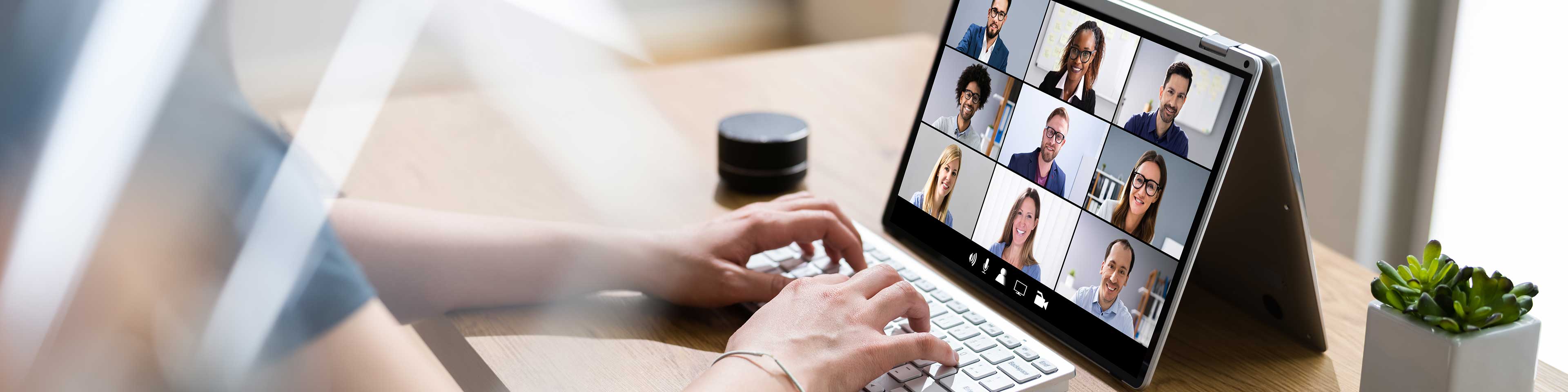 woman typing on a tablet, tablet has video conference going on