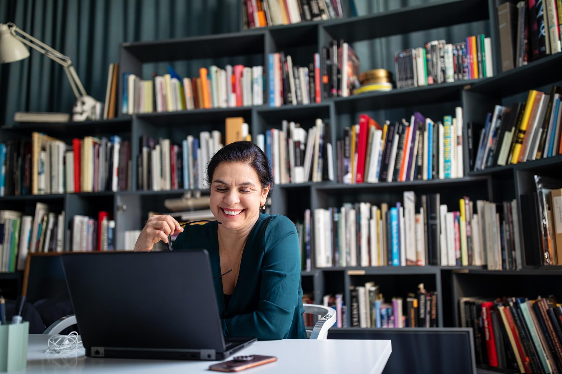 Happy Professional with laptop and books