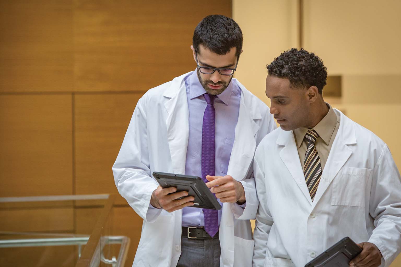 two doctors discussing information displayed on a tablet
