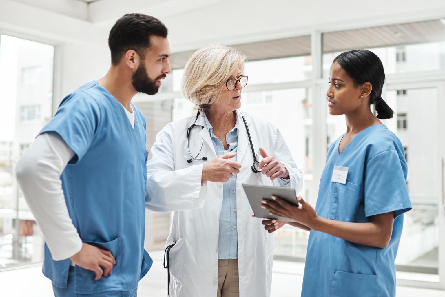 Group of three healthcare workers discussing patient care