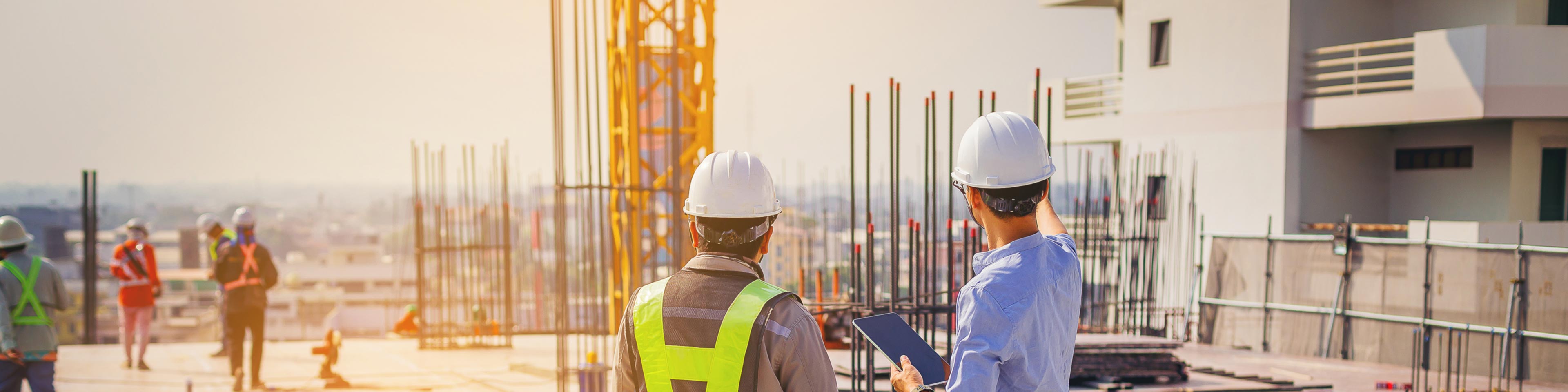 Two construction workers with hardhats on a construction site