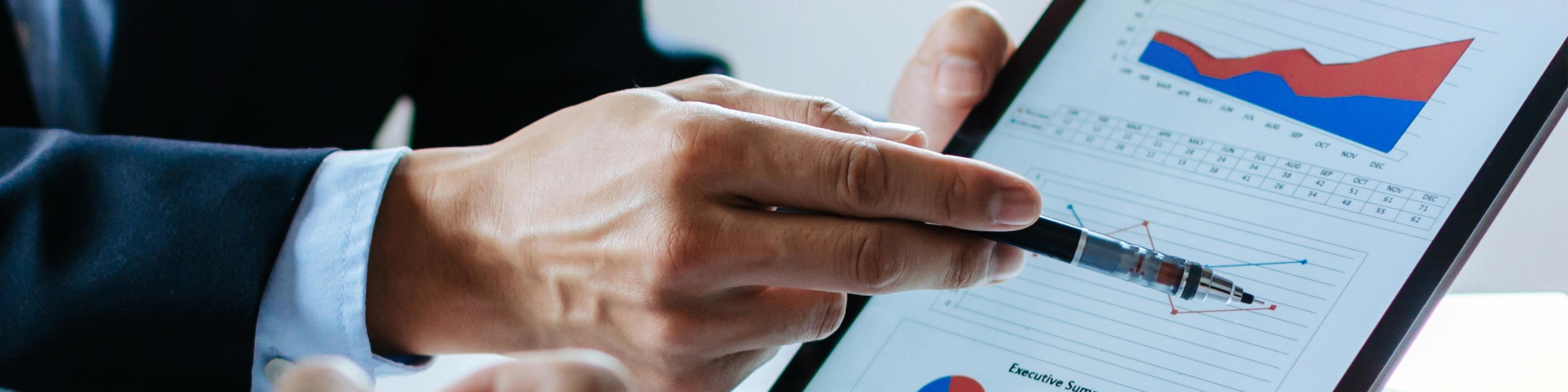 man's hand showing data analytics on a tablet