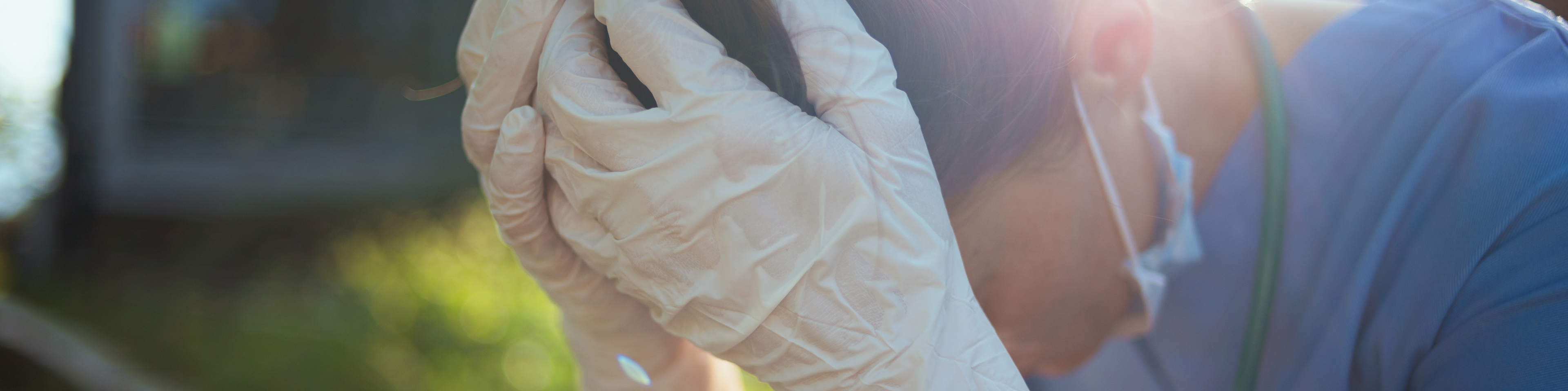 Stressed healthcare worker sitting outdoors near hospital