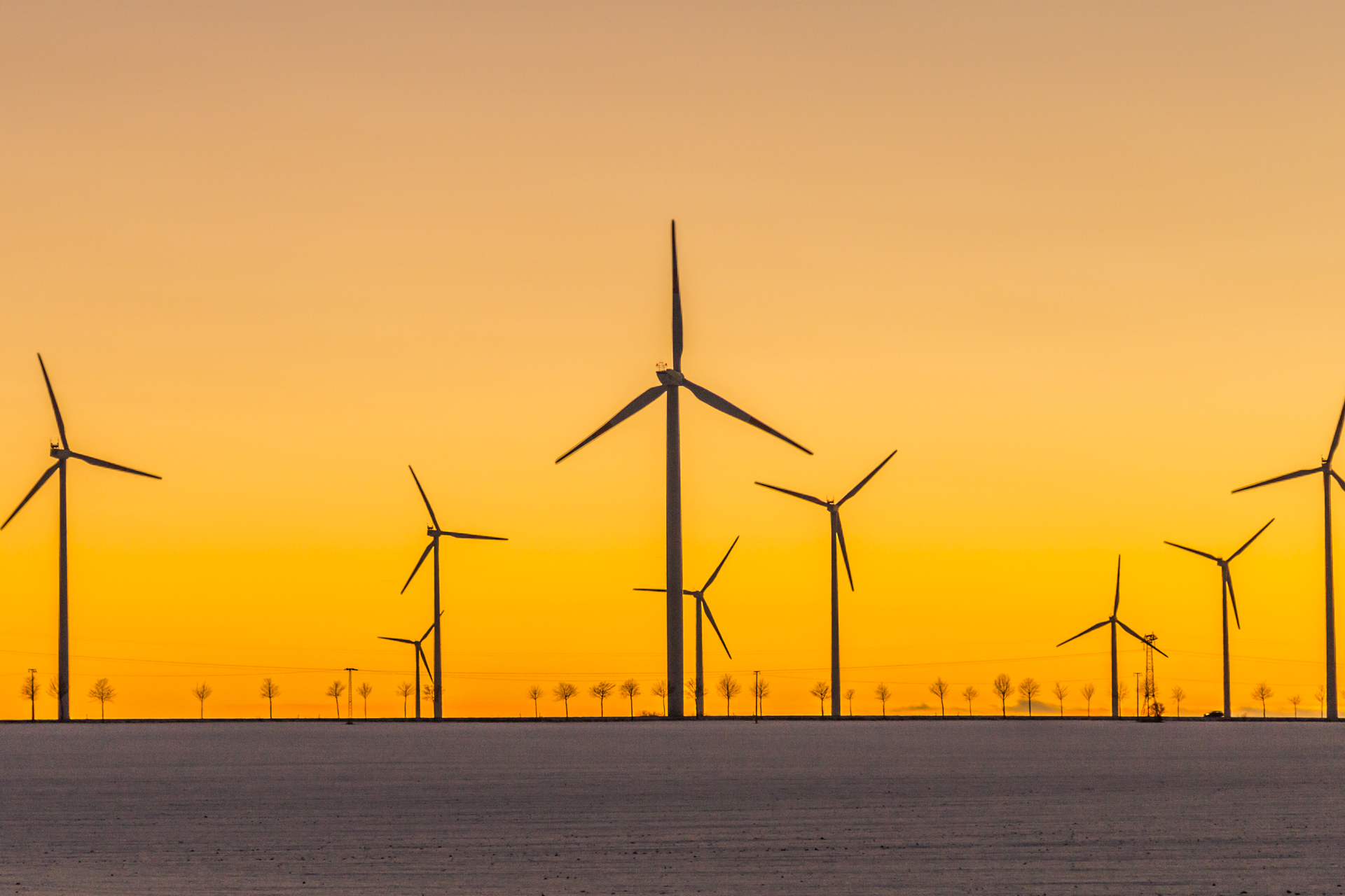 Many wind generators in sunset
