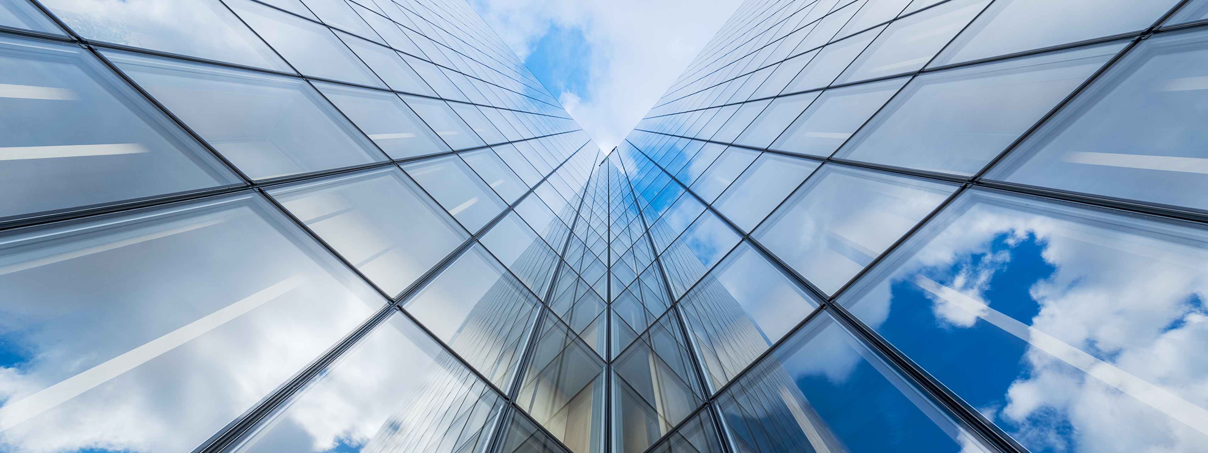 Blue sky and clouds reflections on a glass building,