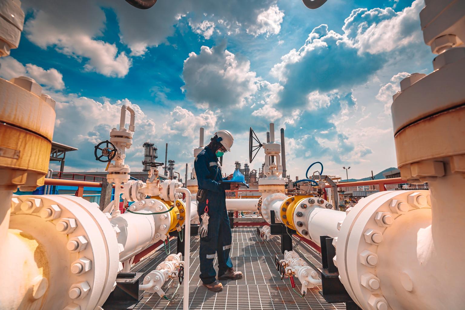 Male worker inspection at steel long pipes and pipe elbow in station oil factory during refinery valve of visual check record pipeline tank oil and gas industry