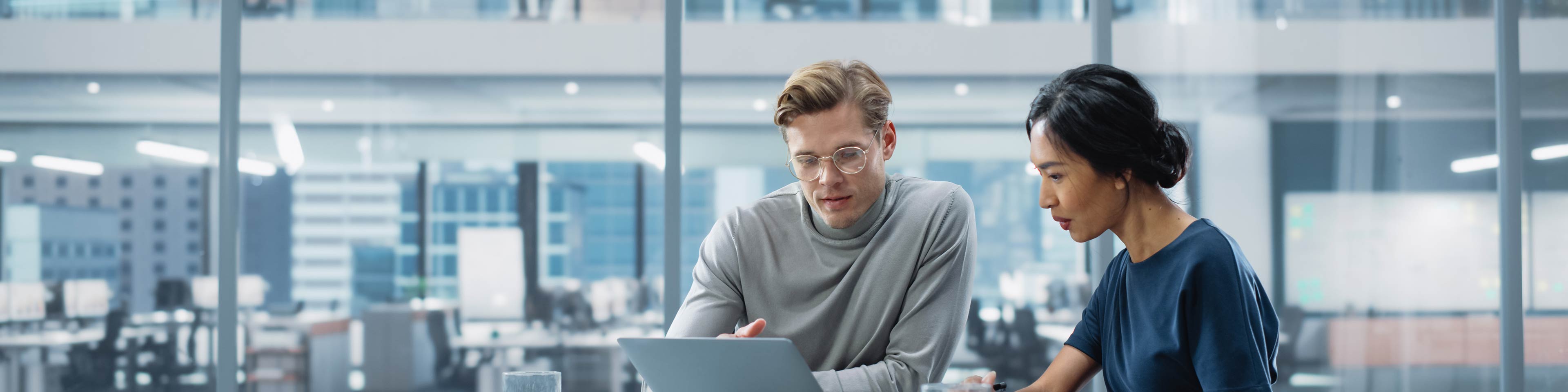 Two business people discussing something in an office setting