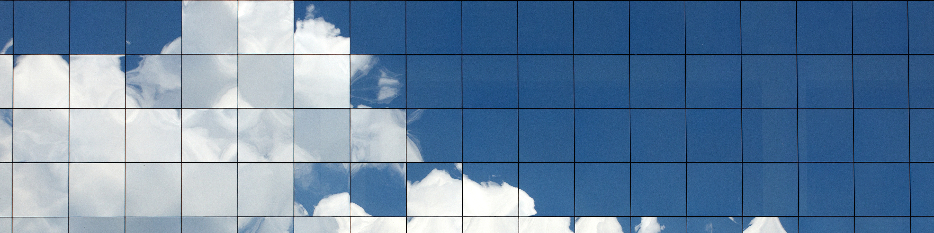 Clouds reflected in windows of modern office building