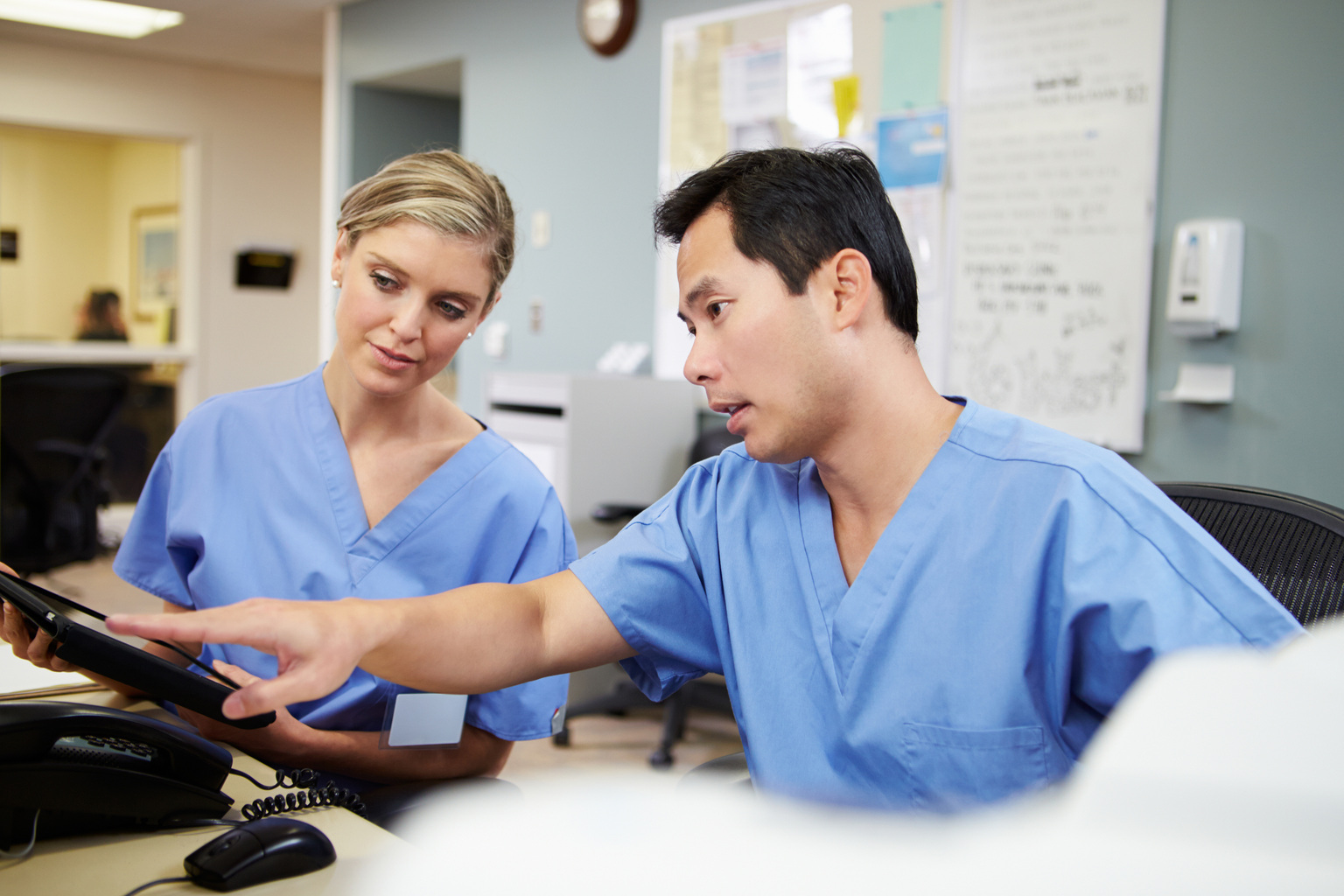 Male and female nurses working at nurses' station