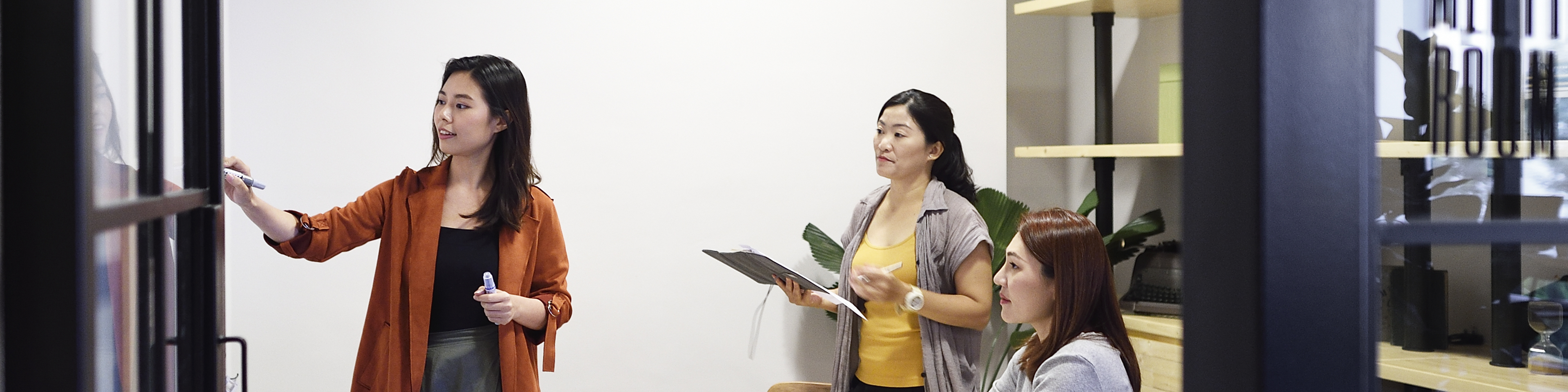 Chinese women brainstorming in an office at night