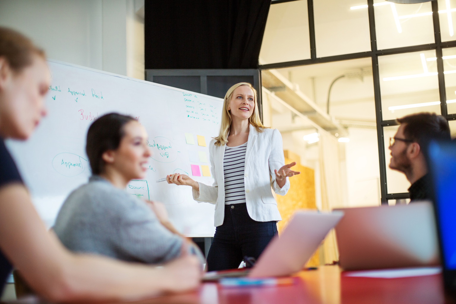 Businesswoman giving presentation on future plans to colleagues