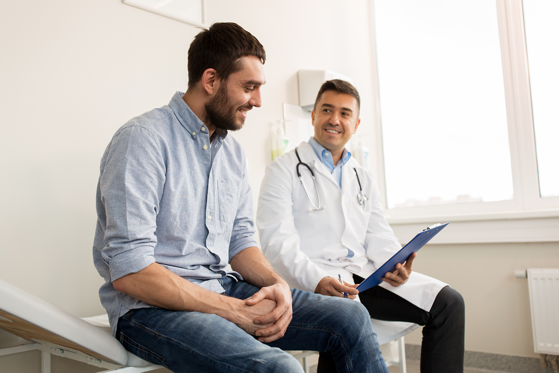 Doctor sitting with patient showing them something in a folder