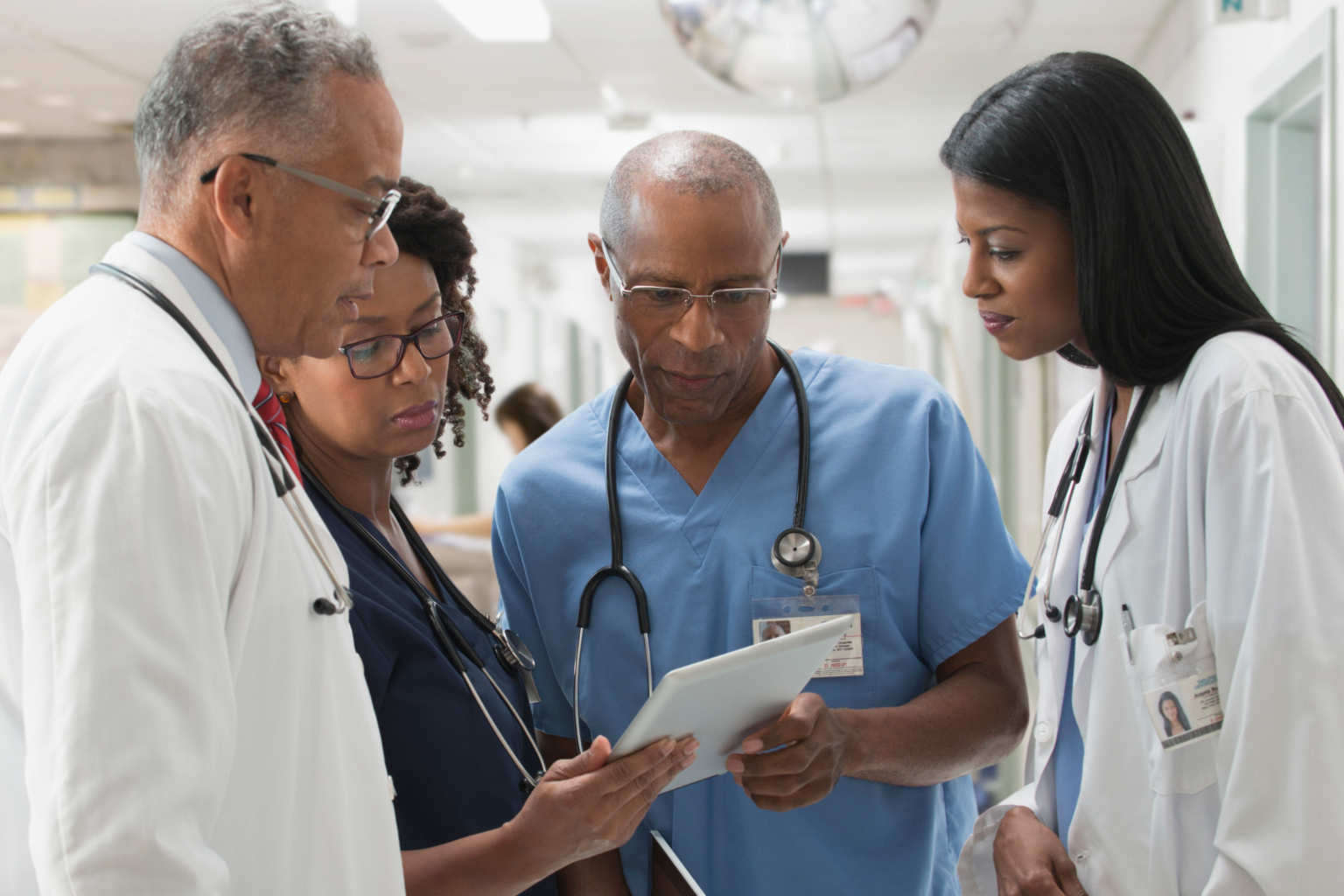 doctors huddle over tablet