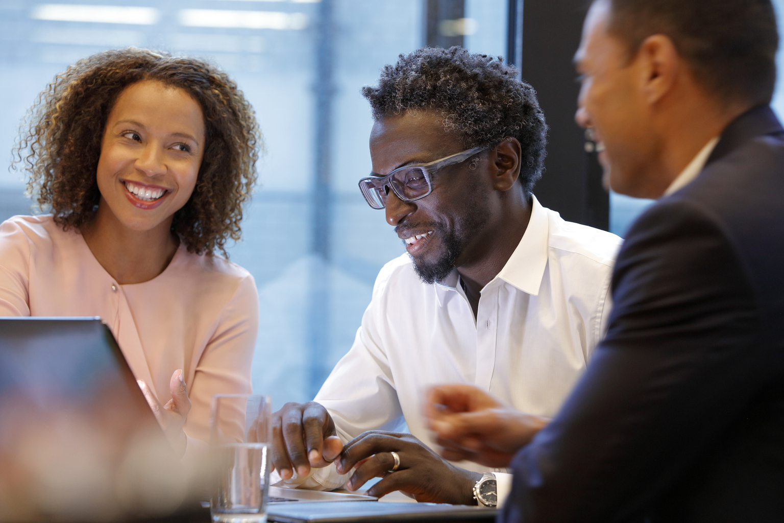 Happy business colleagues discussing at a desk.