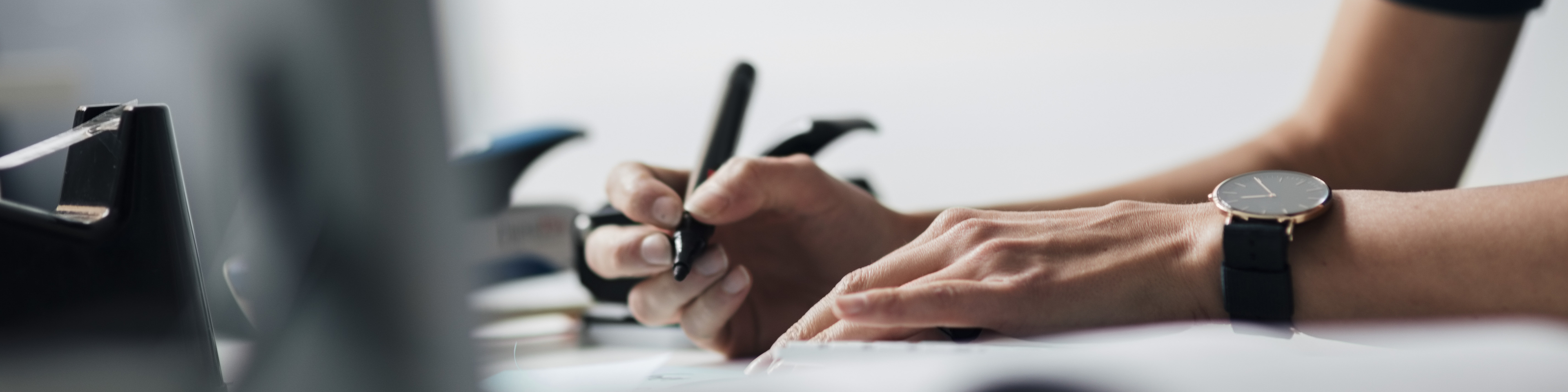 Cropped image of businesswoman writing at desk in office