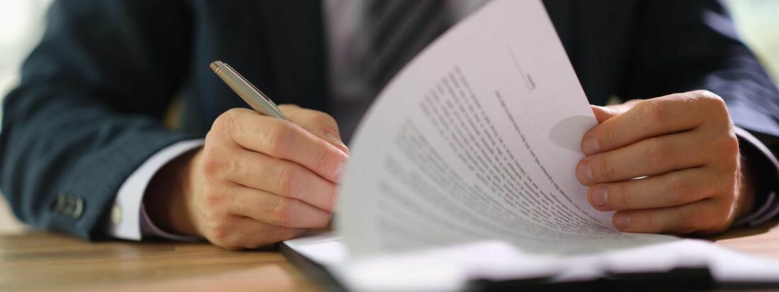 man writing on a document