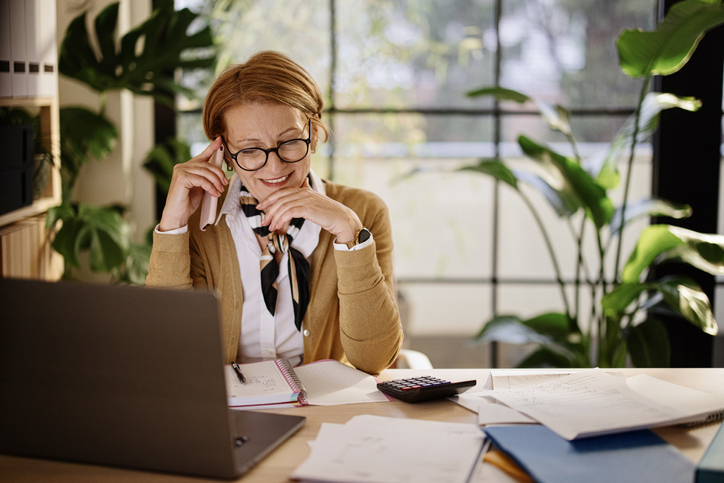  businesswoman using mobile and laptop